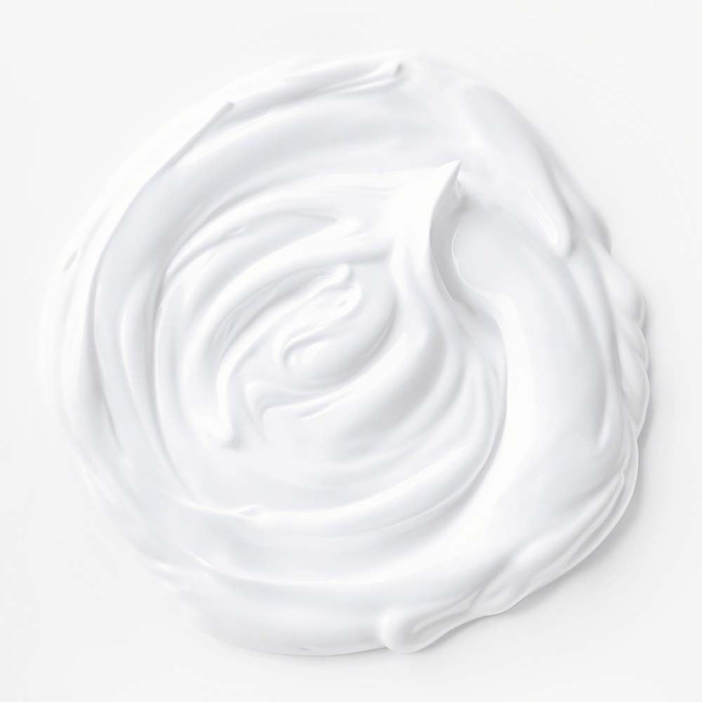 Gros plan d'une crème blanche. La crème est disposée en spirale.