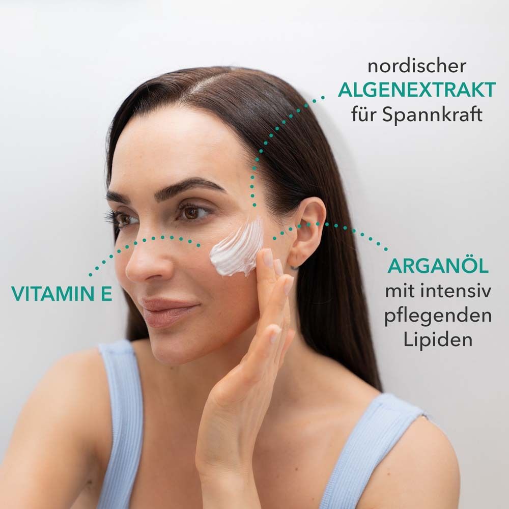 Vrouw met crème op het gezicht. Tekst: Vitamine E, arganolie met lipiden, noordelijk algenextract voor elasticiteit.