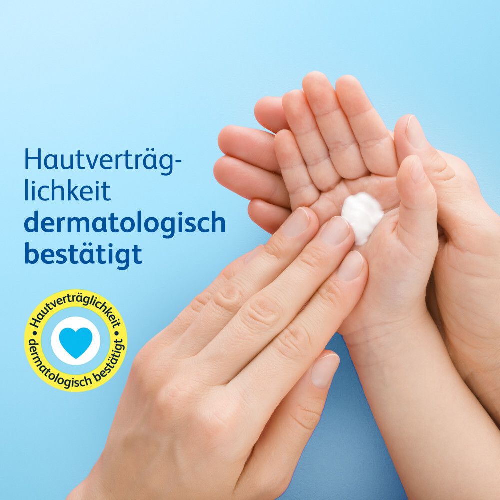 Mains qui crèment la main du bébé. Texte : Tolérance cutanée testée dermatologiquement. Symbole de cœur.