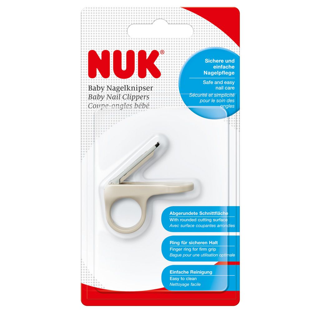 Coupe-ongles dans son emballage. Logo NUK et nom du produit. Surface de coupe arrondie, anneau pour une prise ferme.