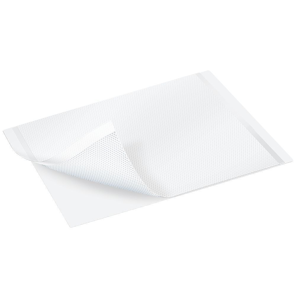 Pansement en silicone. Rectangulaire, perforé. Un coin est soulevé.