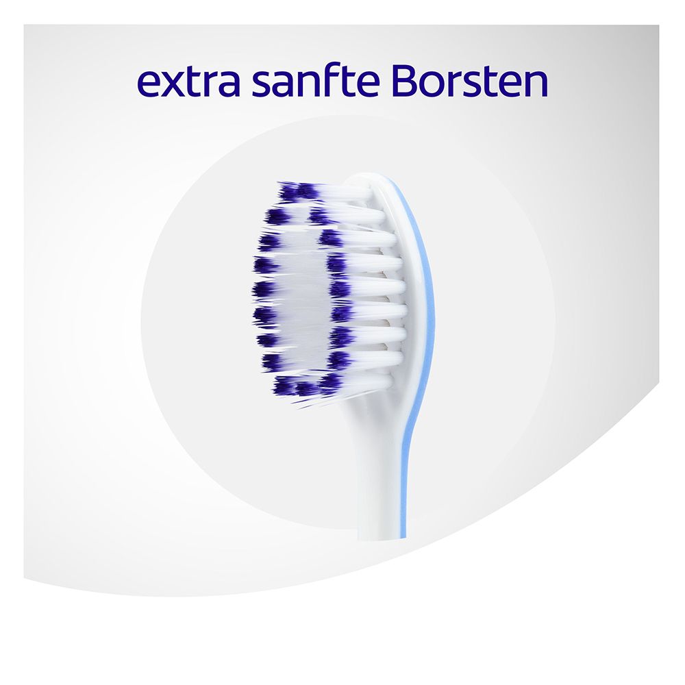 Gros plan de la tête de brosse avec poils bleus et blancs. Texte : 'soies extra douces'.