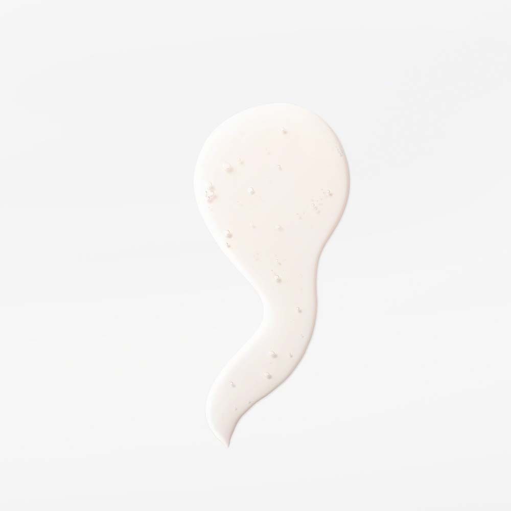 Witte gel op witte achtergrond. Druppelvormig, met kleine deeltjes.
