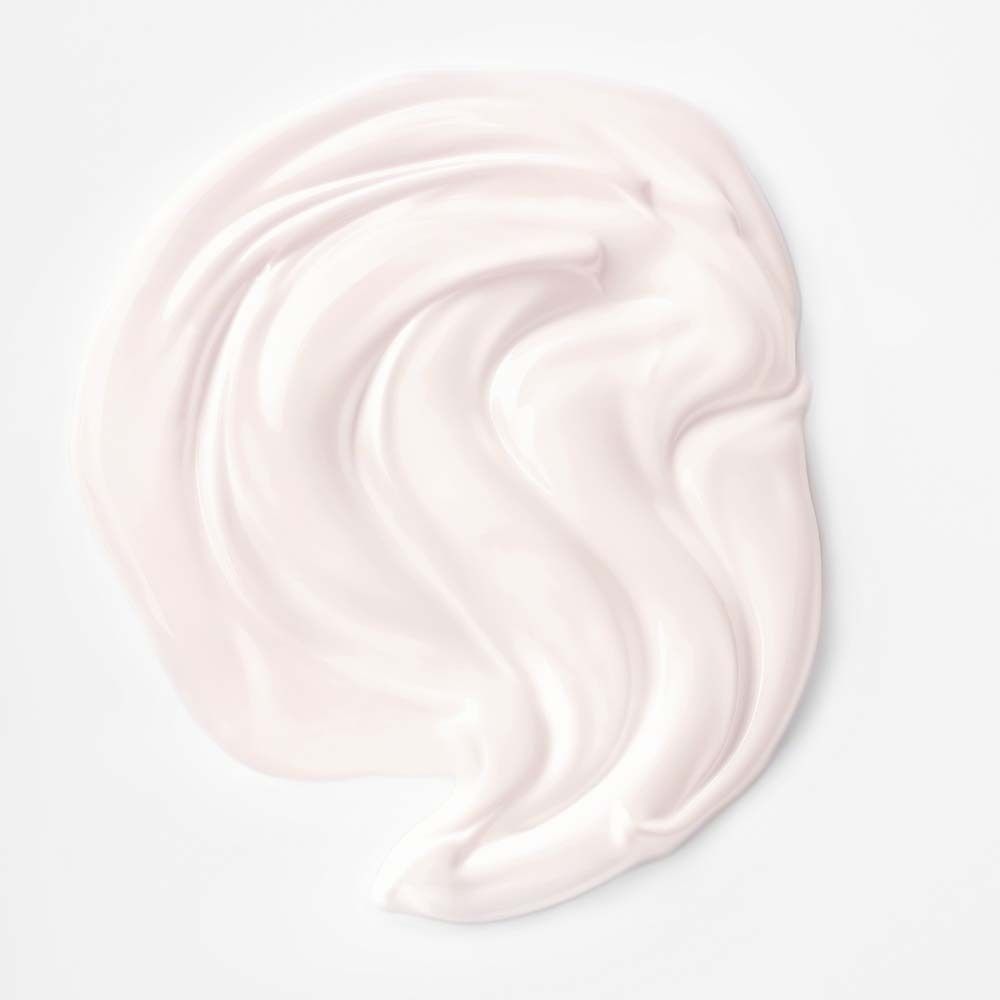 Tache de crème sur fond blanc. Teinte rose. Texture lisse.