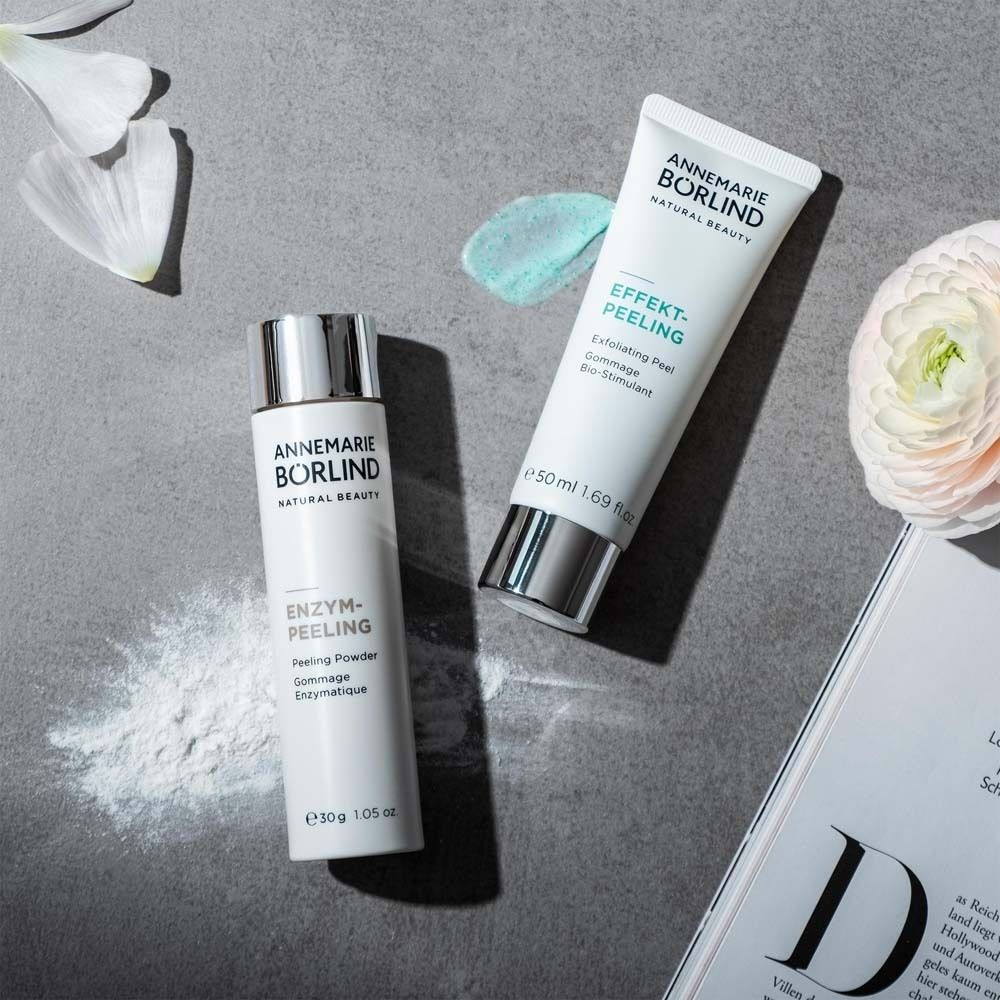 Twee producten en een tijdschrift. Witte cilinder, tube. Opschrift: ANNEMARIE BÖRLIND, ENZYM-PEELING, EFFEKT-PEELING.