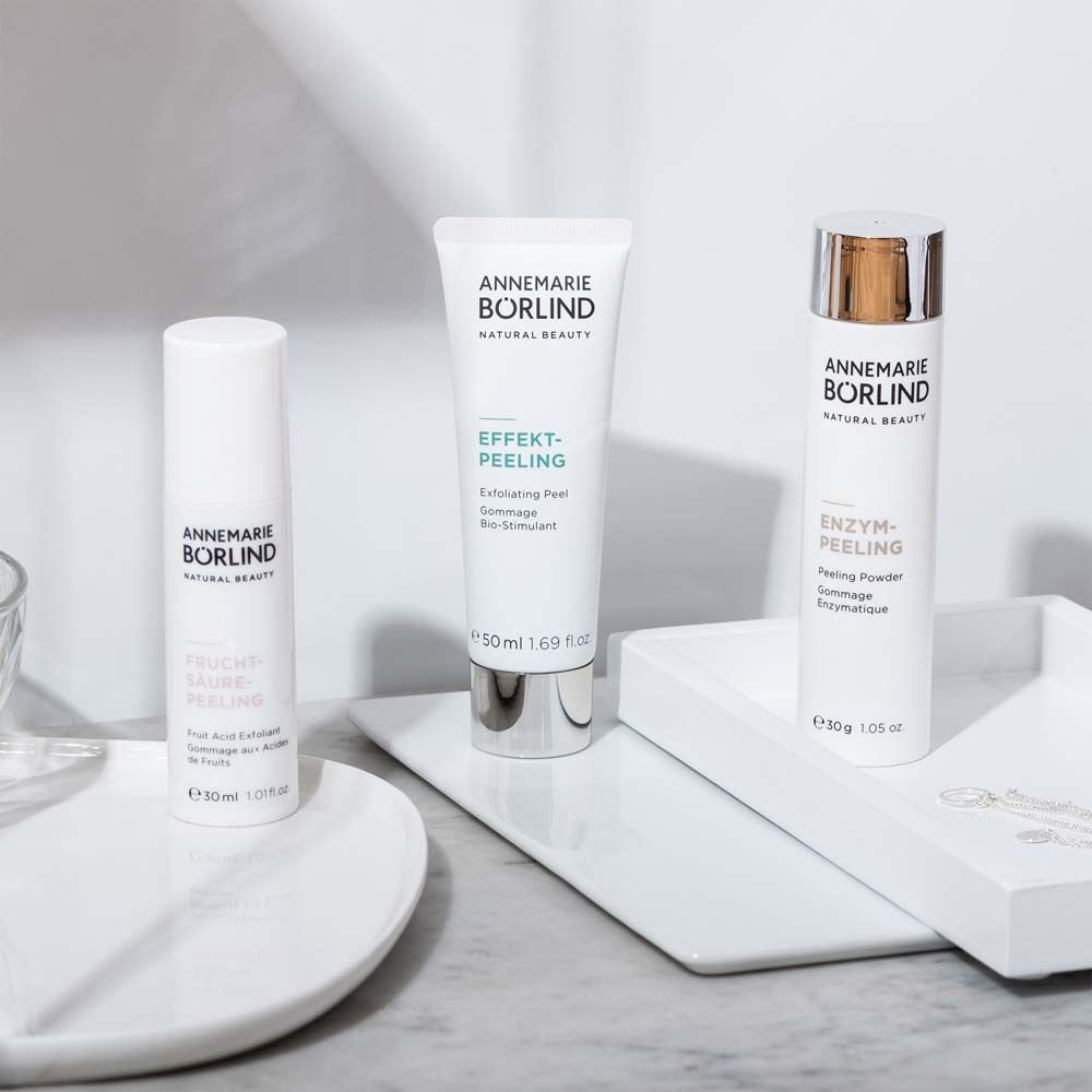 Drie producten op wit dienblad. Opschrift: ANNEMARIE BÖRLIND, ENZYM-PEELING, EFFEKT-PEELING, Fruchtsäure Peeling.