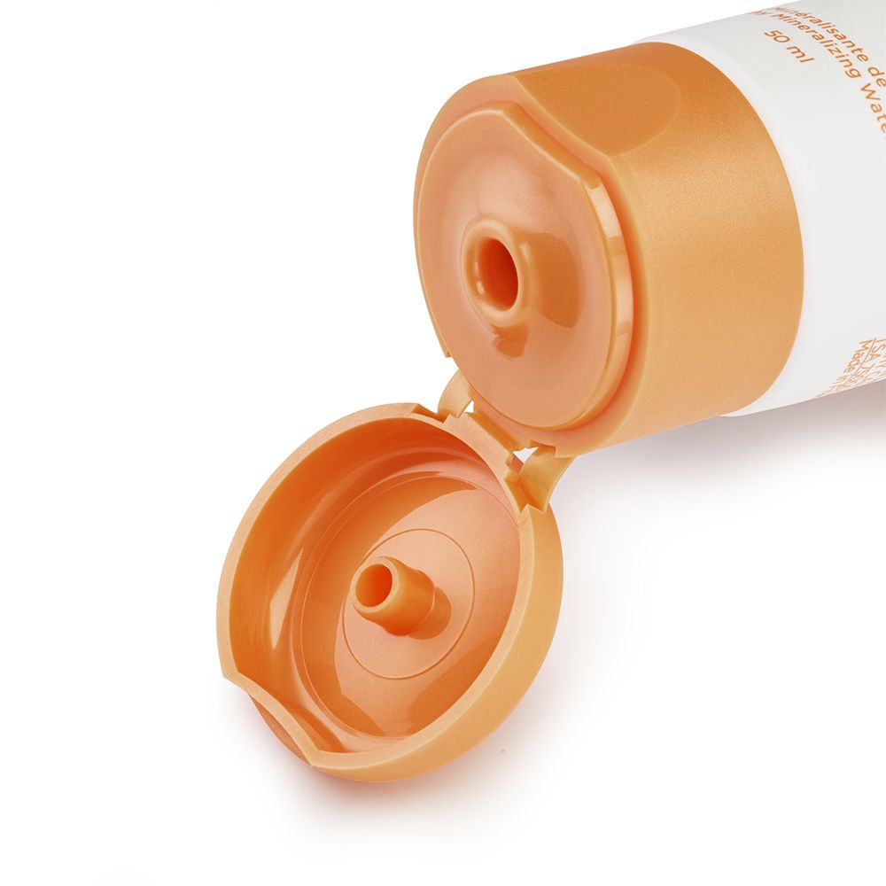 Close-up van de opening van een tube. Oranje dop.