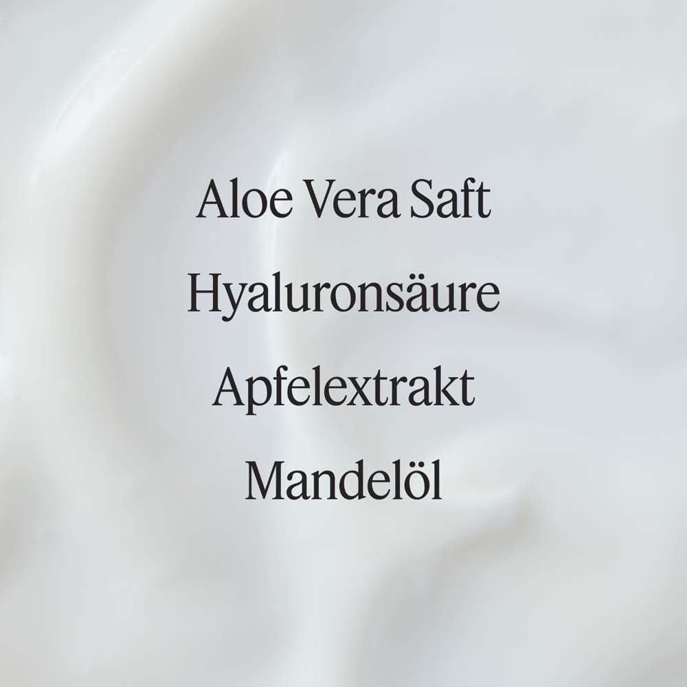 Close-up van crème. Tekst: Aloë Vera sap, Hyaluronzuur, Appelextract, Amandelolie. Witte, romige textuur.