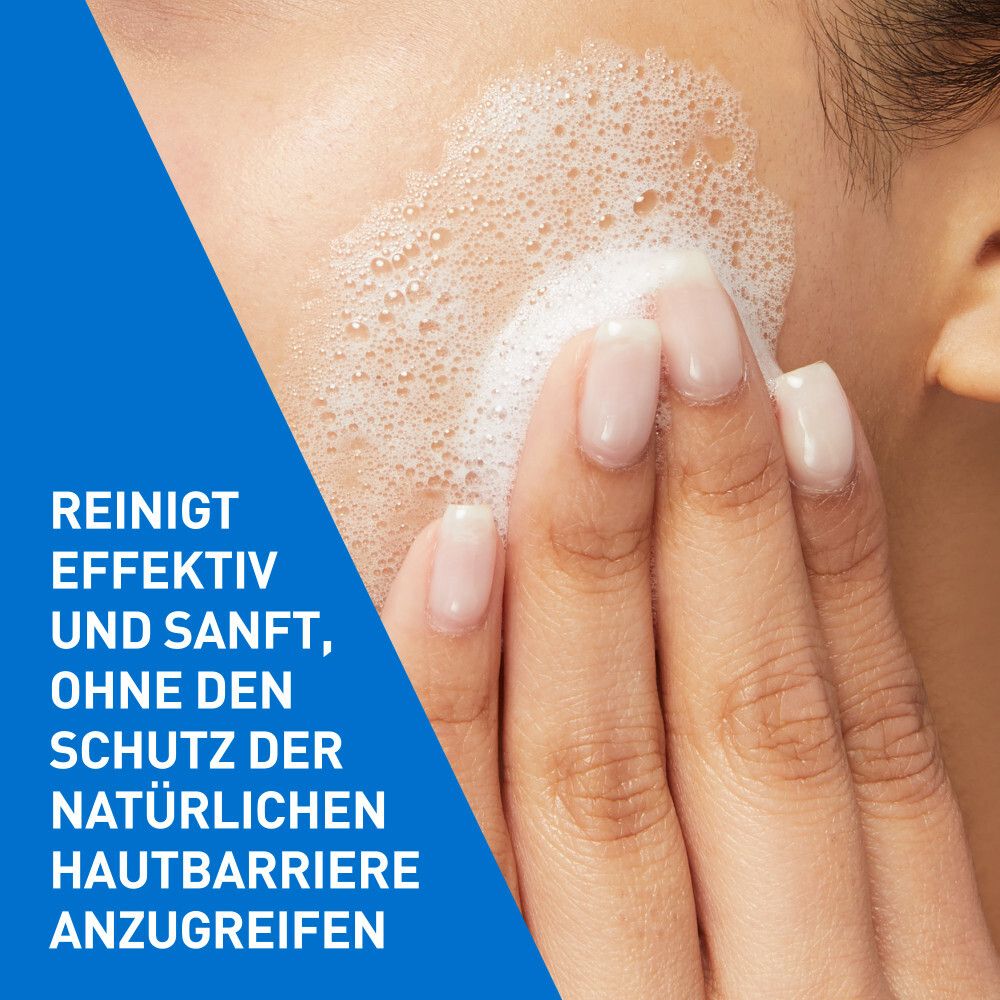 Une main applique doucement de la mousse sur la peau. Des bulles de mousse blanche recouvrent la peau.
