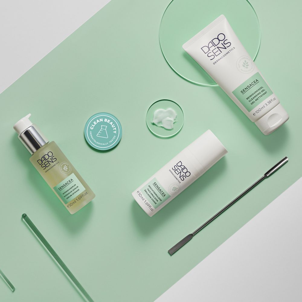 DADO SENS SENSACEA producten en accessoires op groene achtergrond. Reinigingsgel, serum, spatel, druppels.
