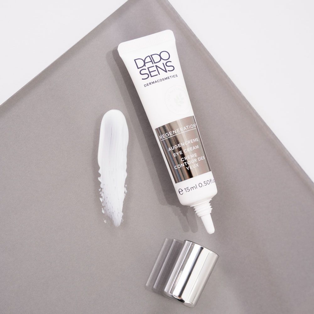 Tube blanc et bouchon argenté avec crème. Inscription: DADO SENS, REGENERATION, Crème contour des yeux.