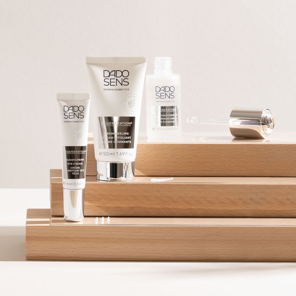 Ensemble de produits sur bois. Tube, crème, flacon. Inscription: DADO SENS, REGENERATION, Crème contour des yeux.