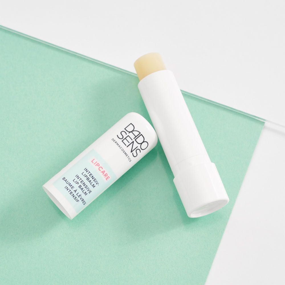 Twee lippenbalsems. Merk: DADO SENS. Tekst: LIPCARE. Witte stick met gele punt.