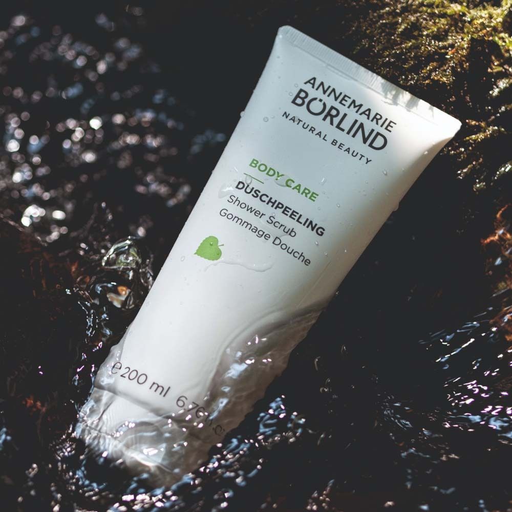 Tube blanche avec impression verte. Gommage douche. Marque : ANNEMARIE BÖRLIND. Repose dans l'eau.