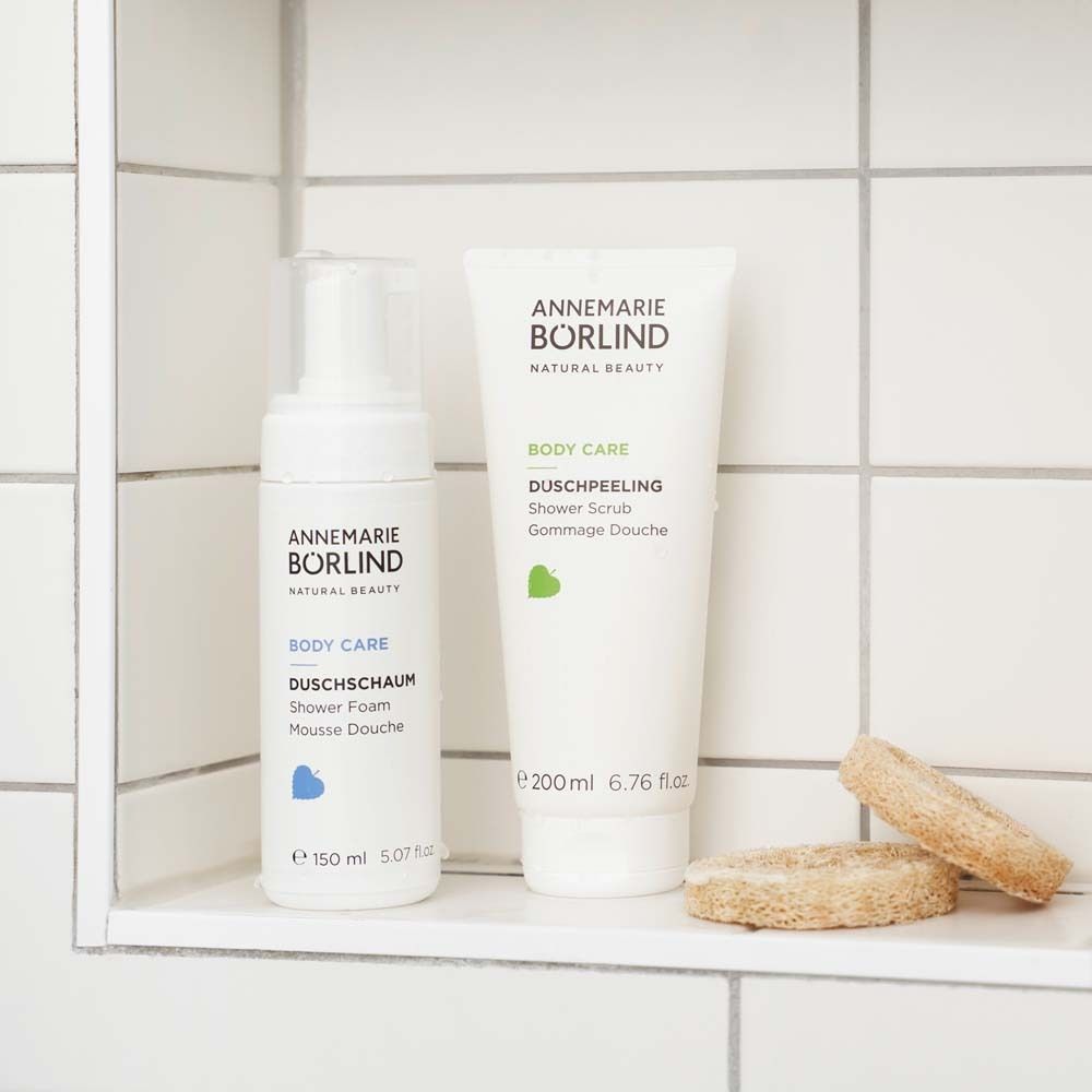 Deux produits sur une étagère. À gauche : Mousse de douche. À droite : Gommage douche. Marque : ANNEMARIE BÖRLIND.