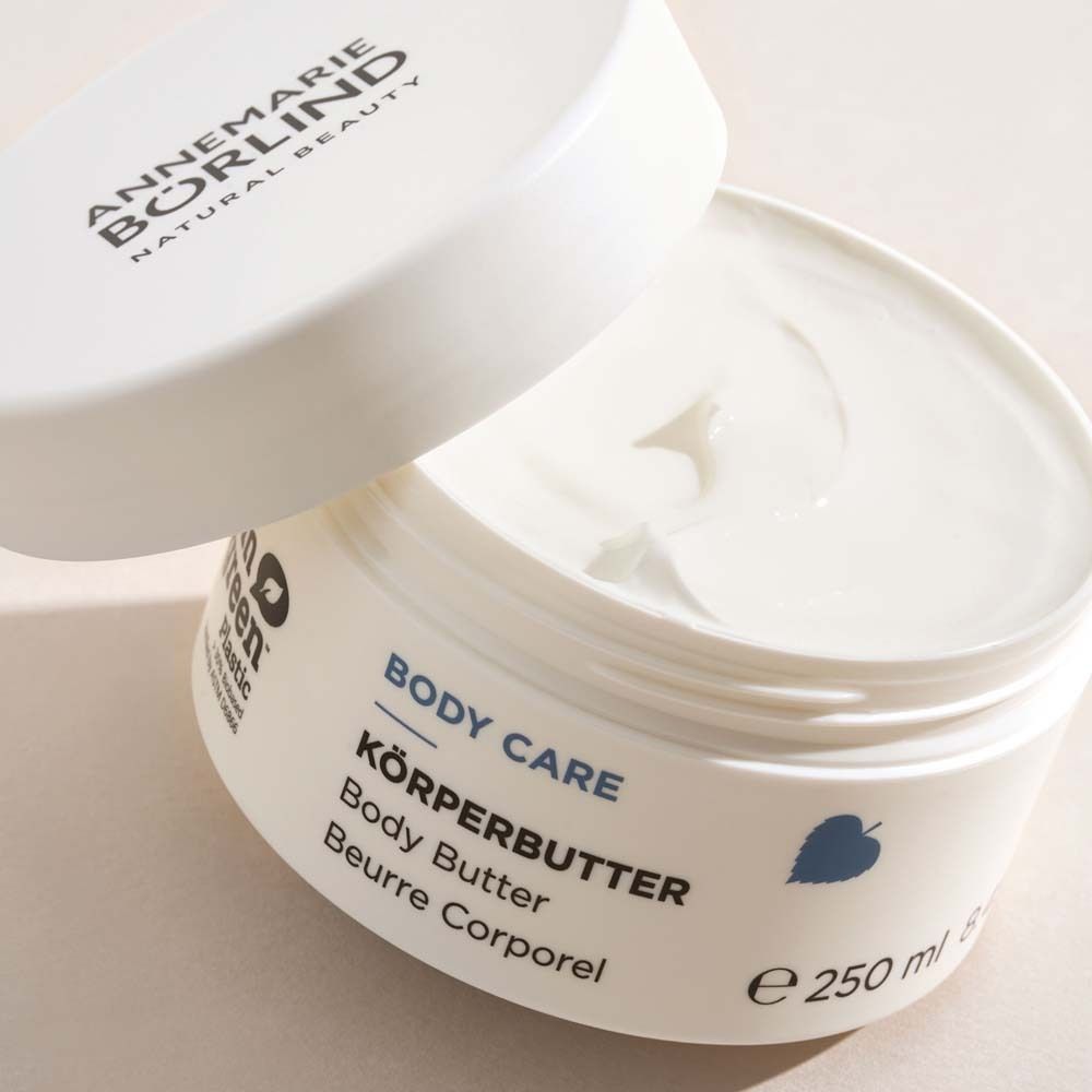 Pot blanc avec couvercle ouvert. Inscription BODY CARE KÖRPERBUTTER. 250 ml.