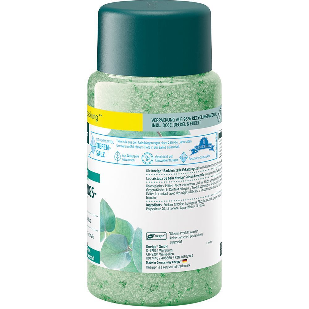 Cristaux de bain verts dans une bouteille transparente avec un bouchon vert foncé. Comprend un design de feuilles d'eucalyptus et des informations textuelles.