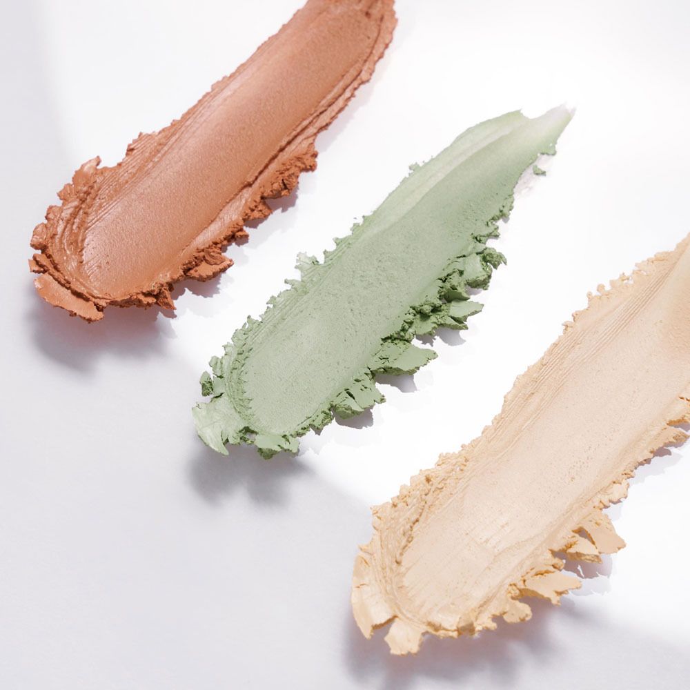 Trois échantillons de correcteur DADO SENS. Jaune, vert et corail. Sur fond clair.