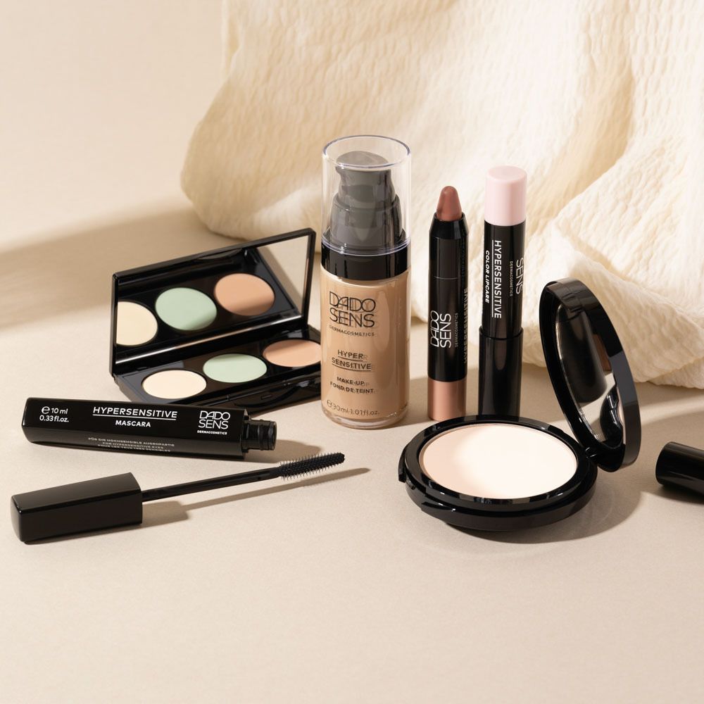 Produits cosmétiques DADO SENS : palette de correcteurs, fond de teint, mascara, poudre, rouge à lèvres. Sur fond clair.