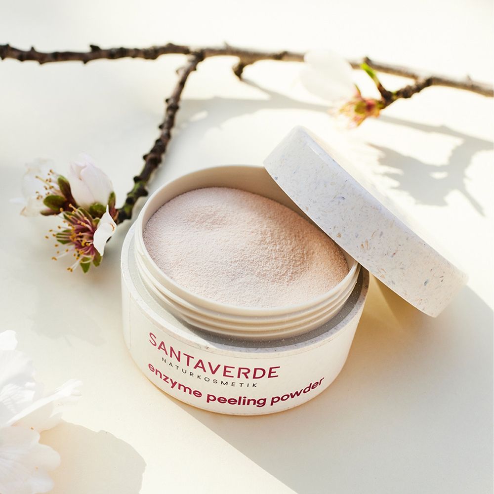 Poudre exfoliante enzymatique Santoverde dans un pot blanc au couvercle ouvert. Poudre fine, rose pâle visible.