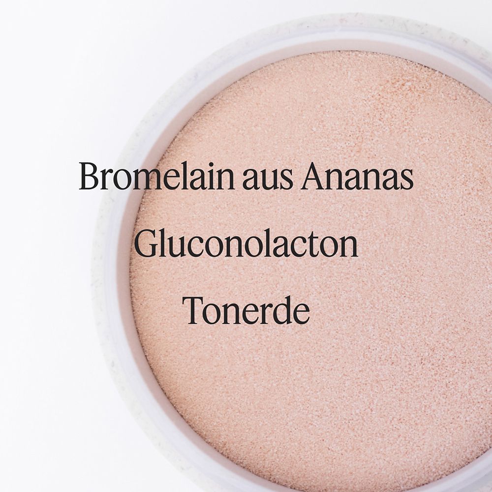 Poudre dans un récipient avec les ingrédients Bromélaïne d'ananas, Gluconolactone et Terre d'argile.