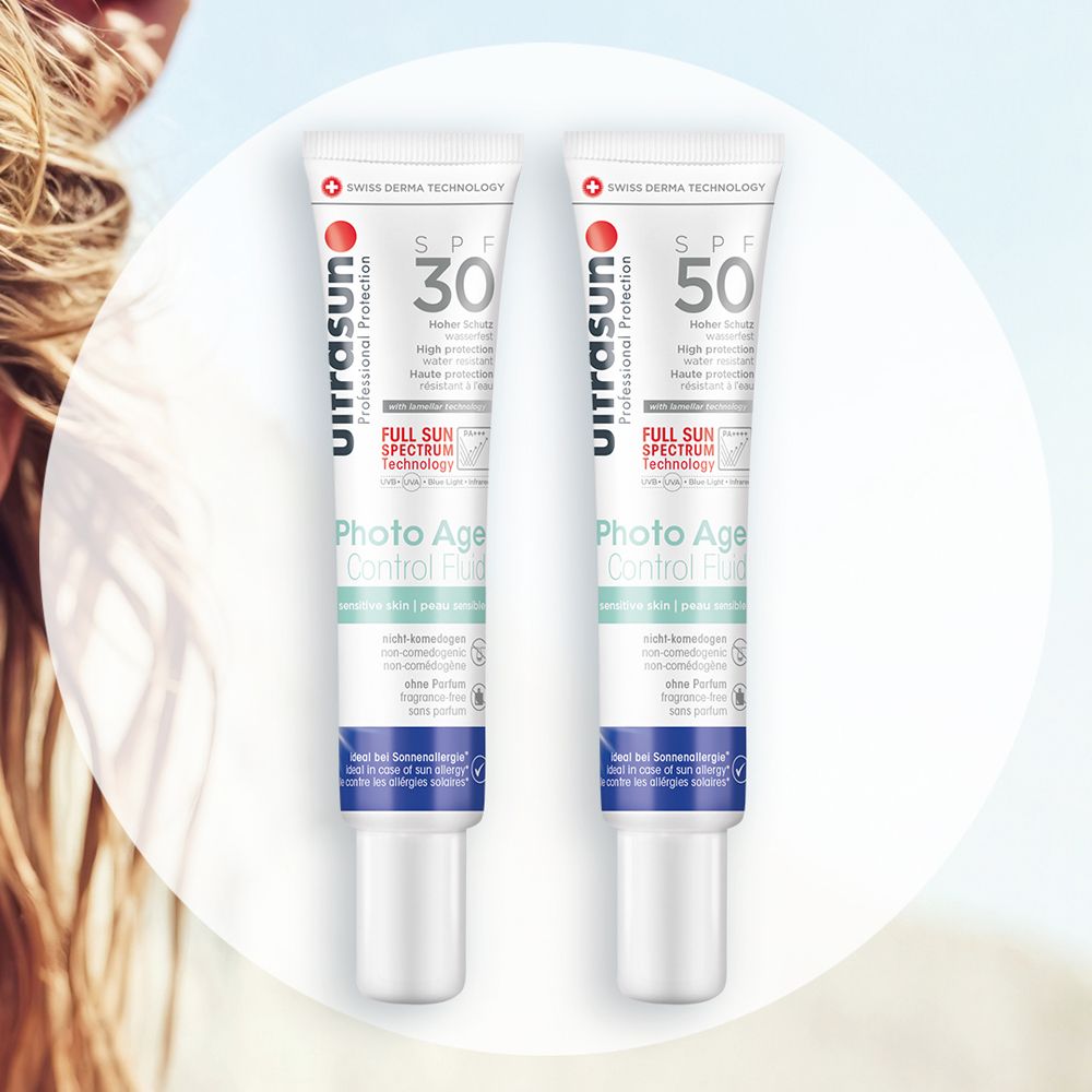 Twee tubes ultrasun Photo Age Control Fluid SPF30 en SPF50. Wit, met rood logo en blauwe tekst. Zwitserse Derma Technologie.