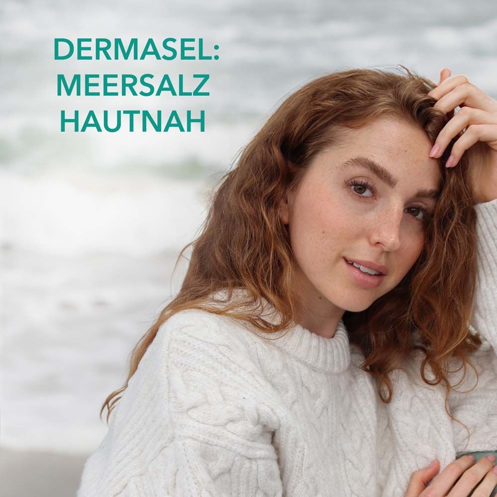 Femme sur la plage. Texte : DERMASEL : Sel de la mer, au plus près de la peau.