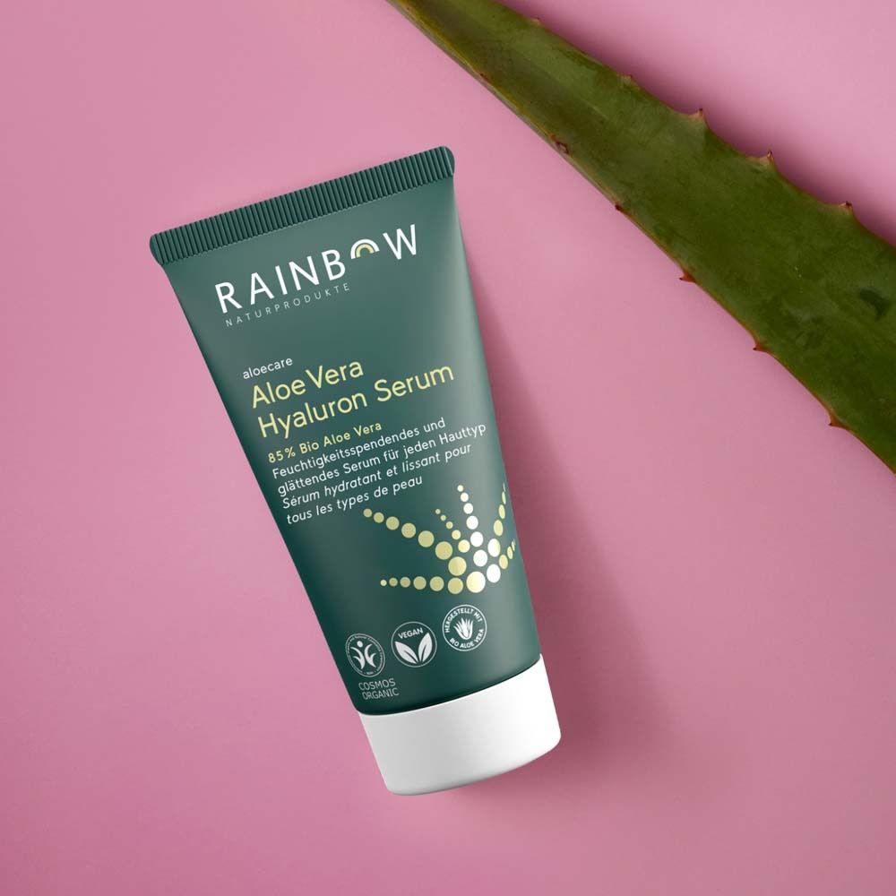 Groene tube op houten schijf. Achtergrond: lichtgroen. Product: Aloe Vera Hyaluron Serum. Vegan- en bio-keurmerk.