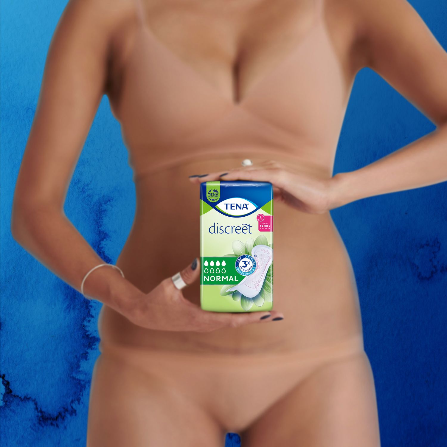 Een persoon houdt een verpakking TENA discreet Normal vast. Verpakking met productafbeelding en logo.