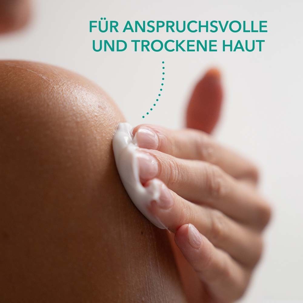 Main appliquant de la crème sur la peau. Texte : Für anspruchsvolle und trockene Haut.