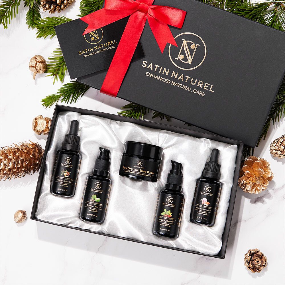Coffret cadeau avec flacons noirs et pots dans une boîte noire avec ruban rouge. Marque : SATIN NATUREL.