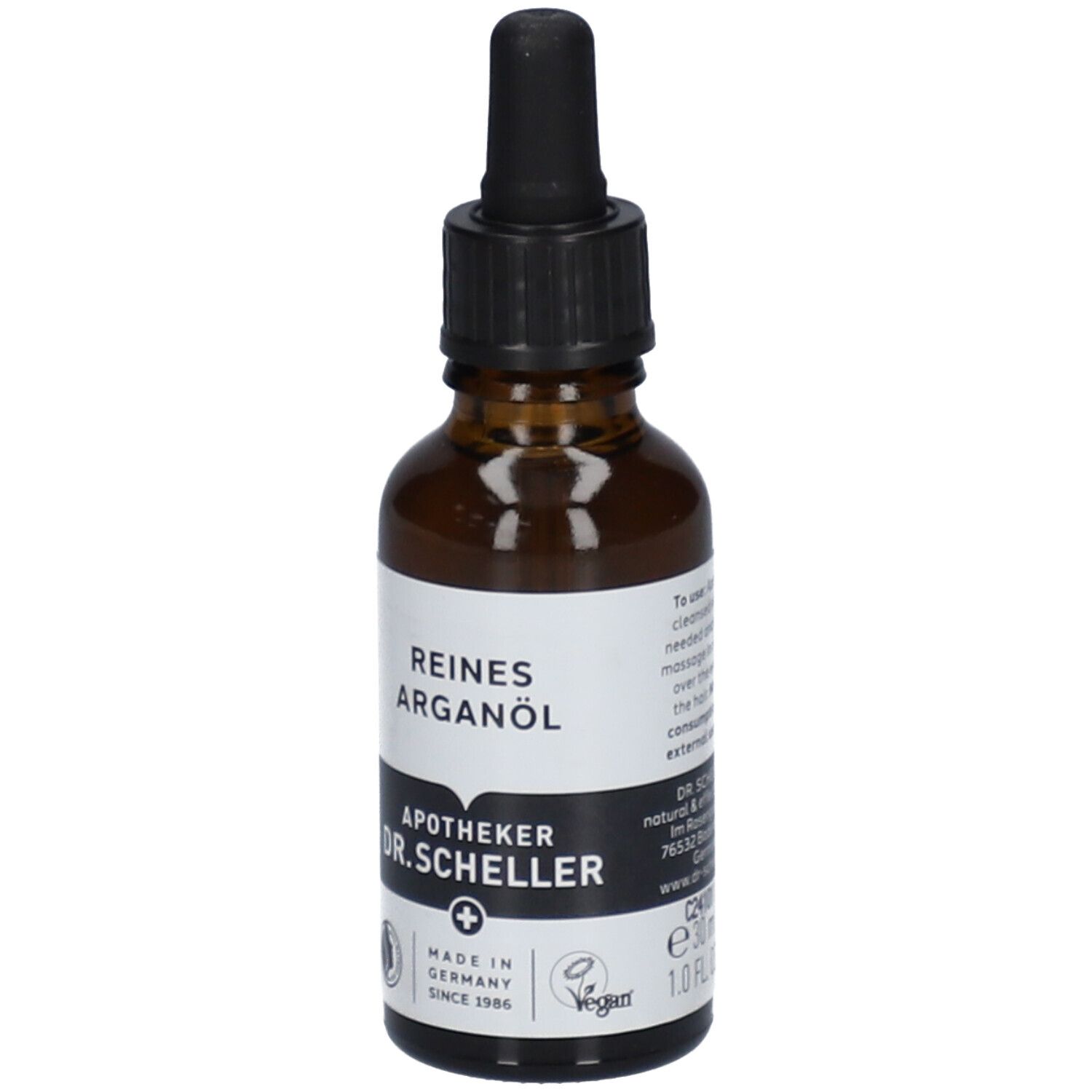 Bruine glazen fles met zwarte dop en pipet. Etiket met "REINES ARGANÖL" en "APOTHEKER DR.SCHELLER".