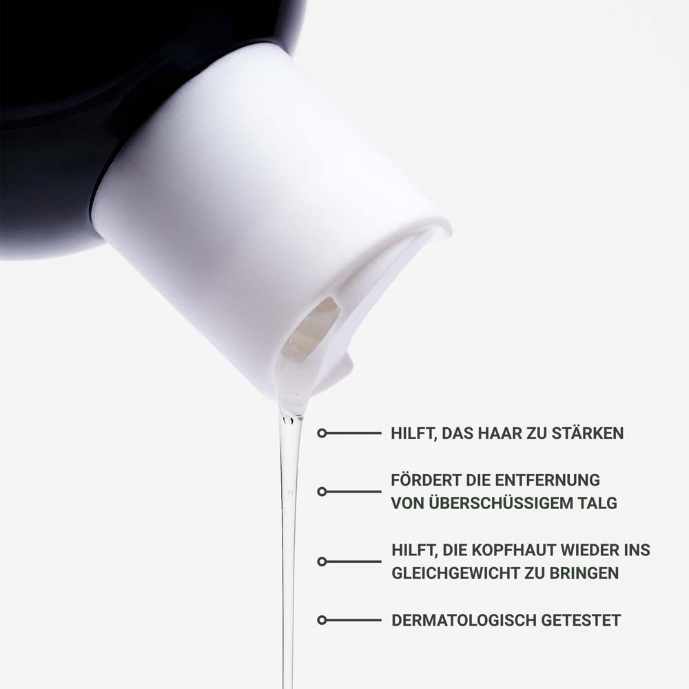 Gros plan sur un flacon de shampooing. Texte : Aide à renforcer les cheveux, à équilibrer le cuir chevelu.