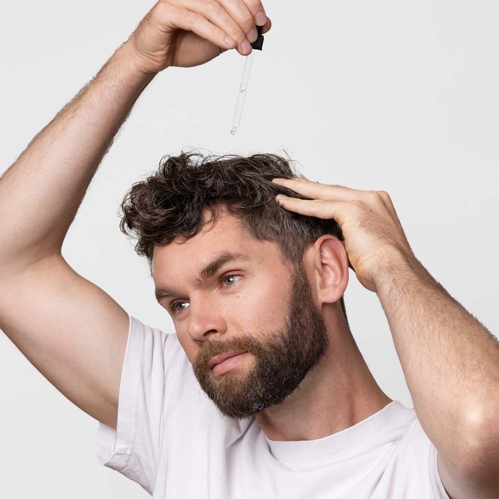 Man houdt pipet boven zijn hoofd. Serum wordt aangebracht.