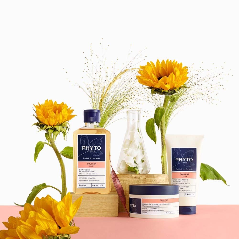 Productarrangement met shampoo, crème en zonnebloemen. Op roze achtergrond.