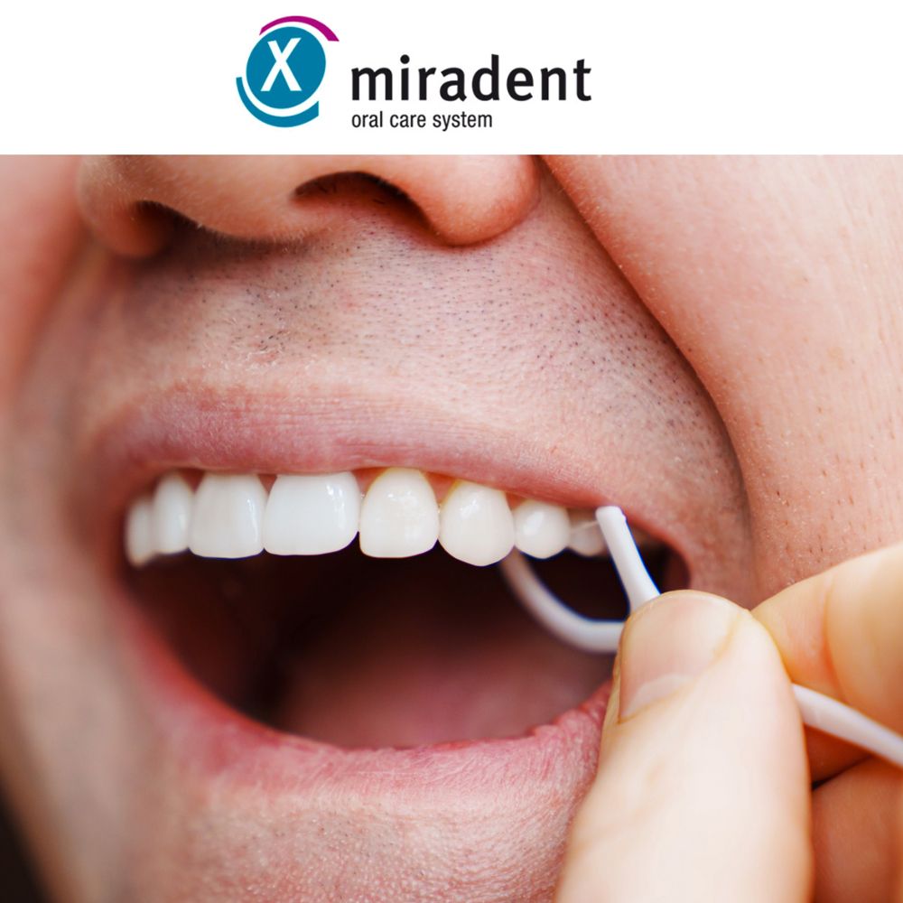 Personne utilise Zahnpick® 2en1 pour se nettoyer les dents. Le fil blanc est entre les dents.