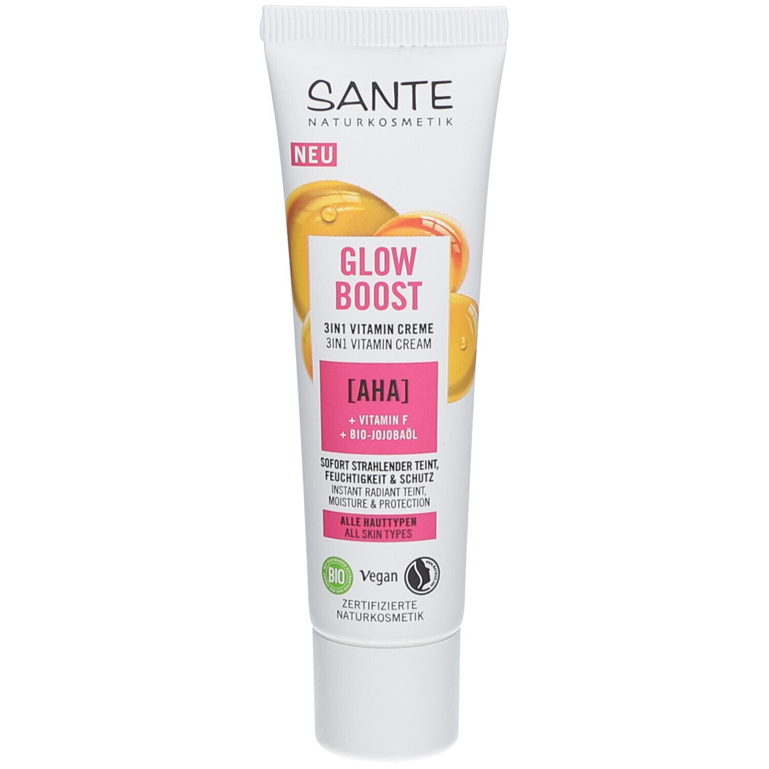 Tube de crème SANTE GLOW BOOST. Inscription : GLOW BOOST 3in1 Vitamin Creme. Contient AHA, Vitamine F, huile de jojoba bio. Tous types de peau.