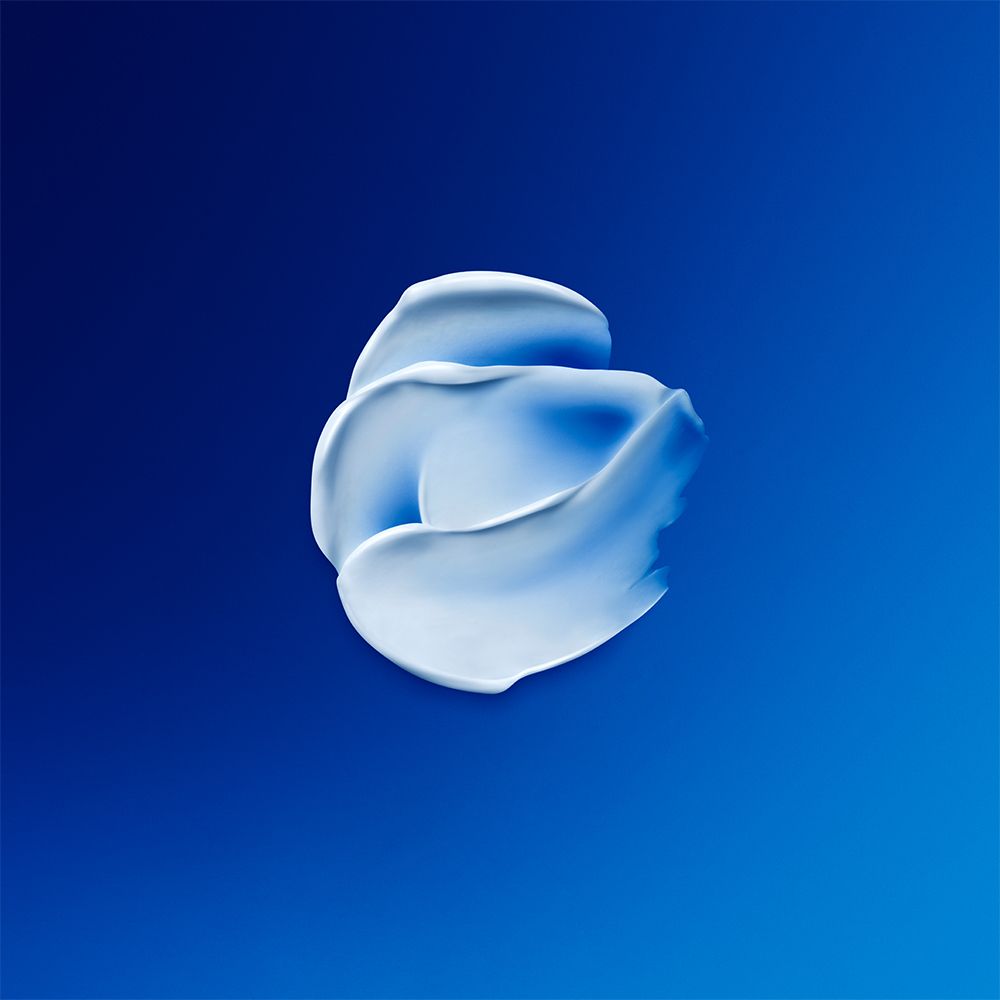Produit crème blanc sur fond bleu. Texture crème.