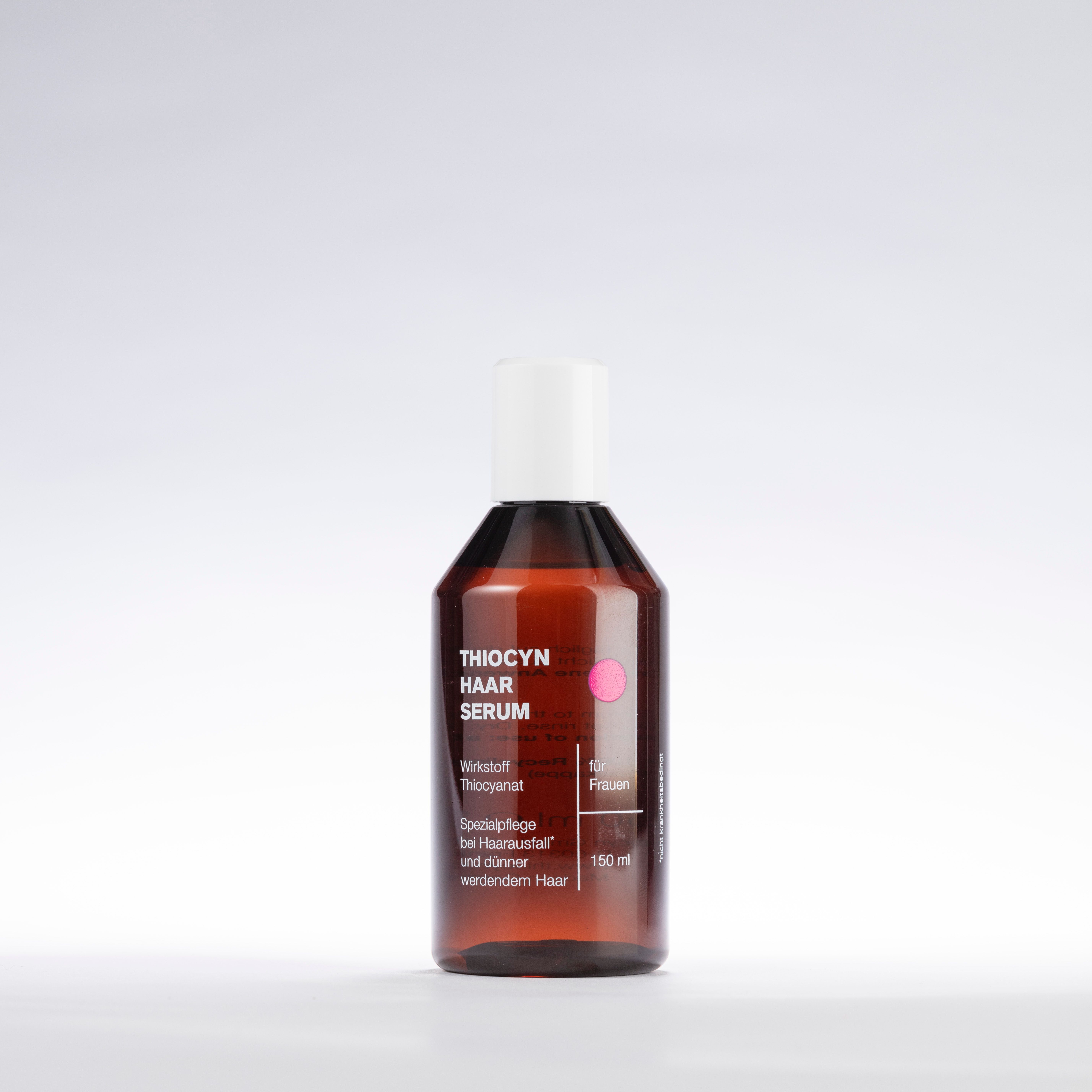 Flacon de sérum capillaire Thiocyn, marron, bouchon blanc, point rose. Sur fond clair.