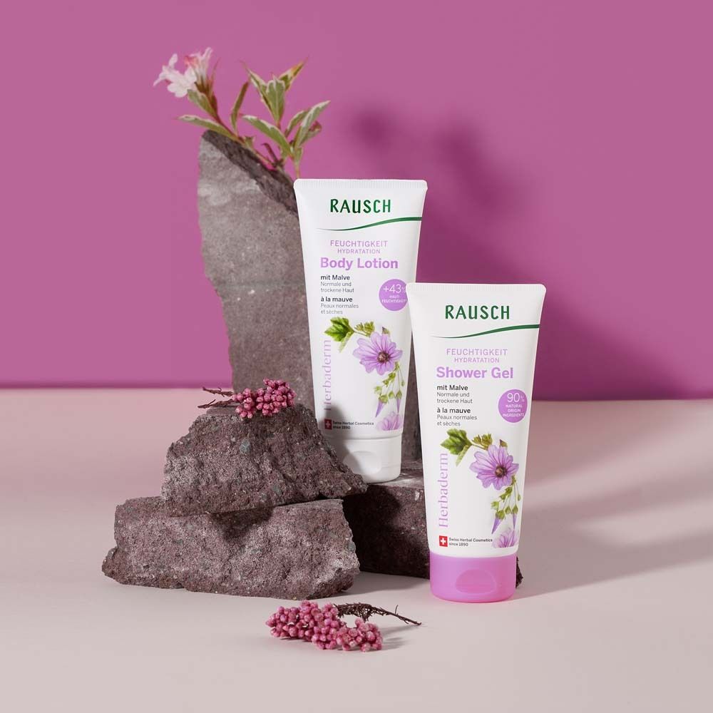 Deux tubes sur des pierres. Lotion corporelle et gel douche. Tubes roses et blancs. Sur fond violet.