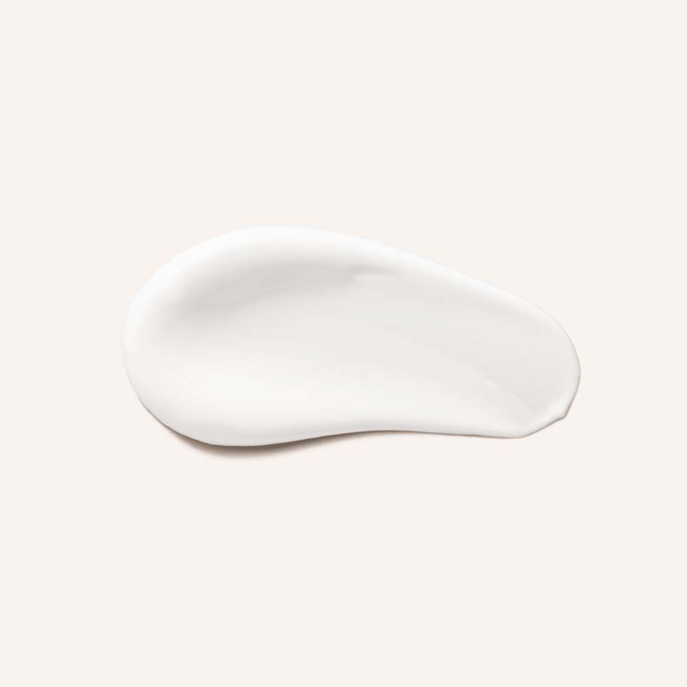 Tache de crème blanche. En forme de goutte. Sur fond clair.