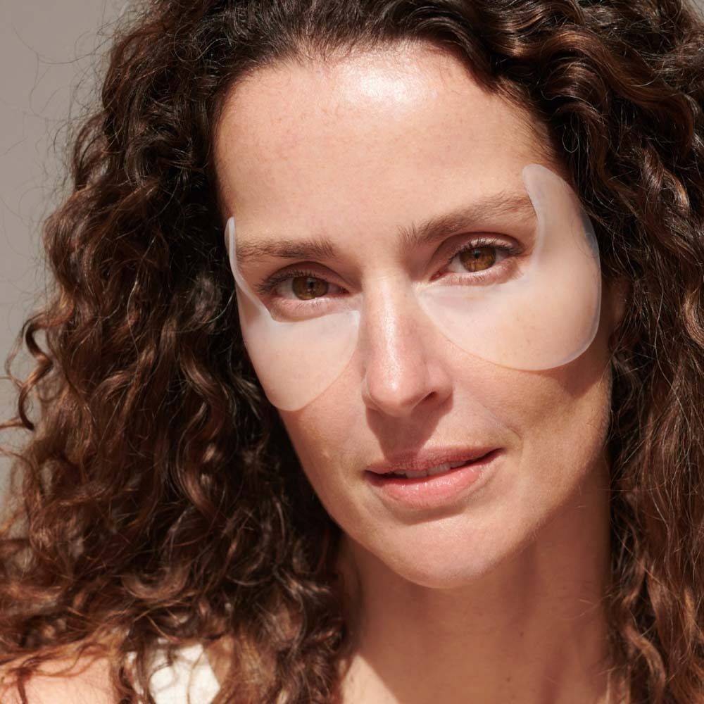 Vrouw met APRICOT Eye Temple Pads op de ogen. De pads zijn transparant en bedekken de oogcontour.