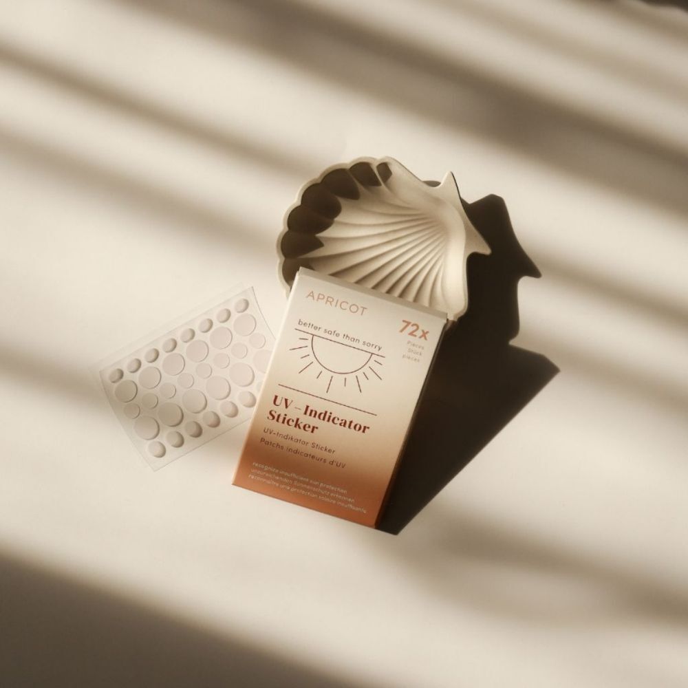 Paquet et stickers à côté d'un coquillage. Marque : APRICOT. 72 pièces.