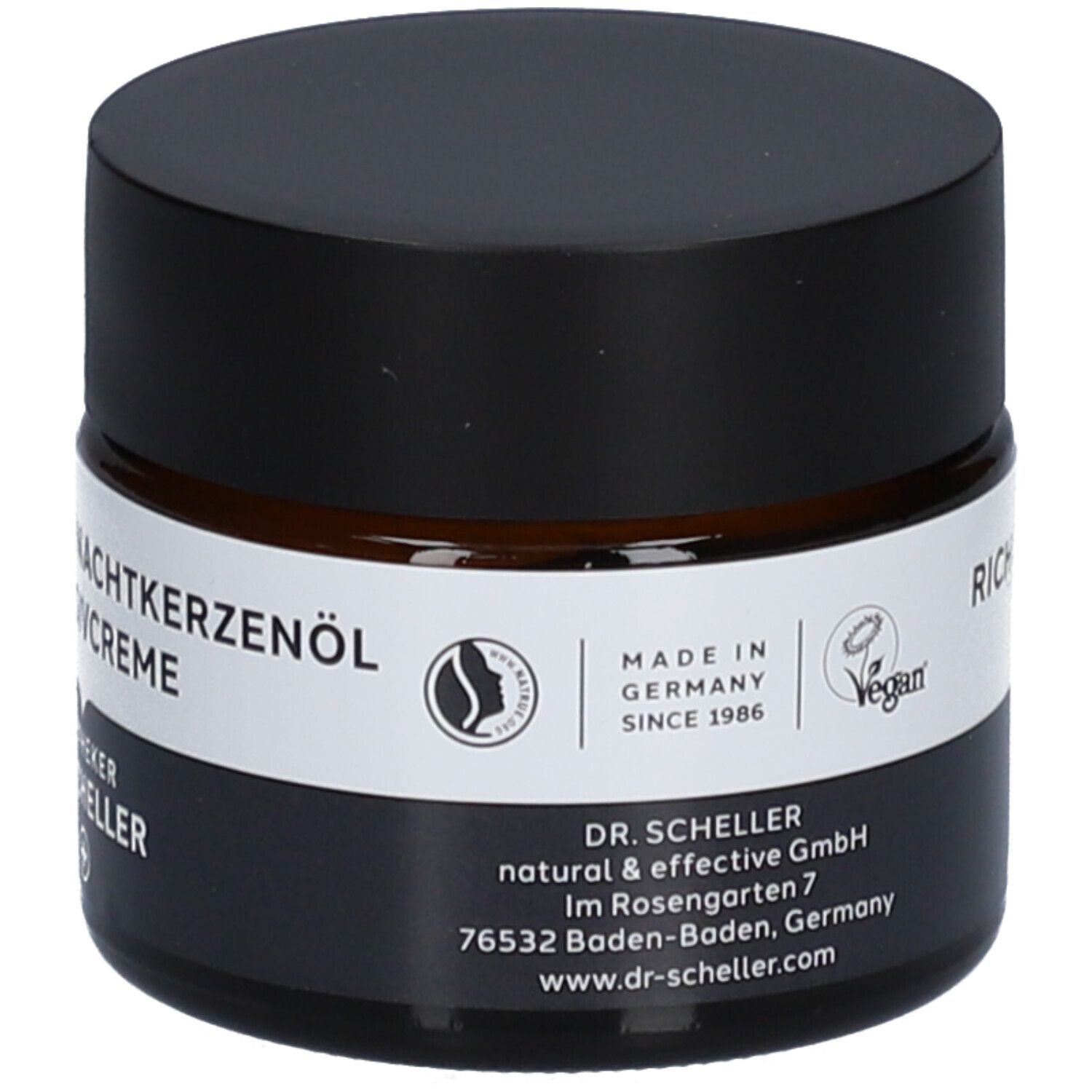 Pot de crème brun avec couvercle noir. Nom du produit sur étiquette blanche. Label vegan.