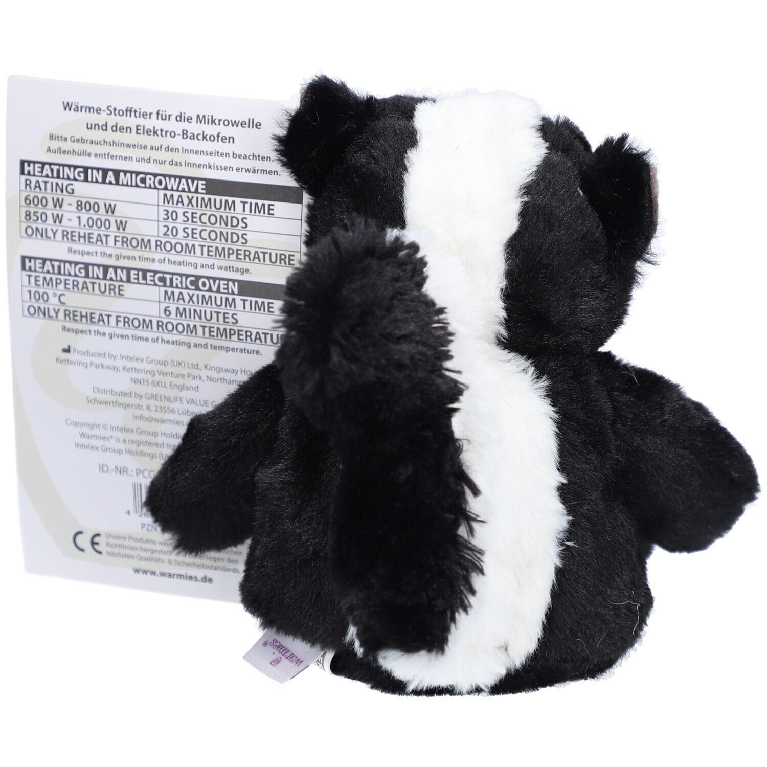Un jouet moufette chauffant en peluche, noir et blanc. Étiquette incluse avec instructions de chauffage pour micro-ondes et four.