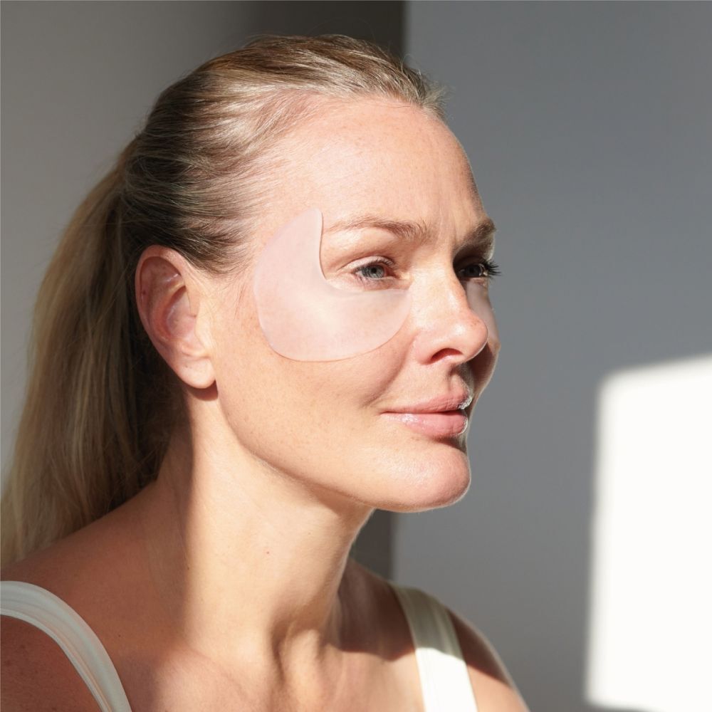Femme avec un coussinet pour les yeux et les tempes sur le visage. Le coussinet transparent couvre l'œil et la tempe.