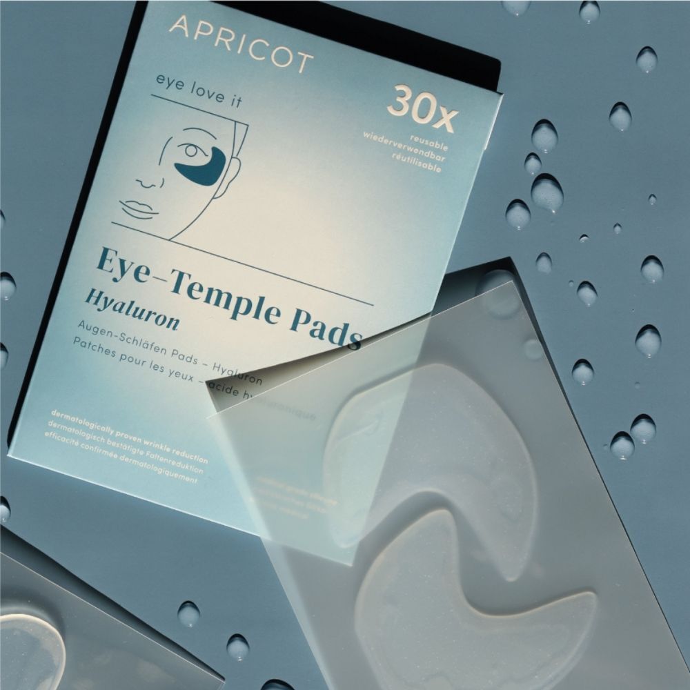 Verpakking met oog-slaap pads en pads. Merk APRICOT. Opschrift: Eye-Temple Pads Hyaluron. Pads ernaast.