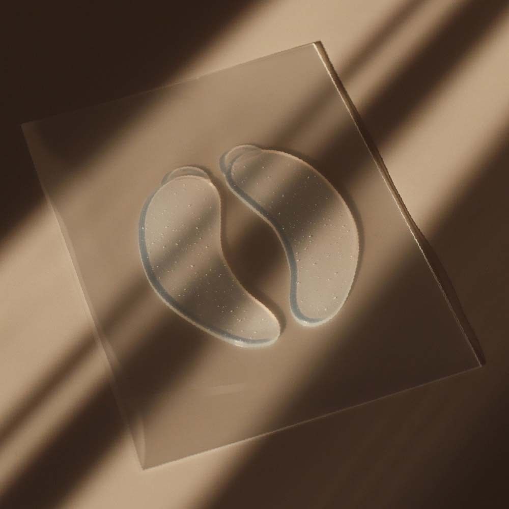 Twee transparante Eye Pads op een transparant oppervlak. Ligt iets schuin in het licht.