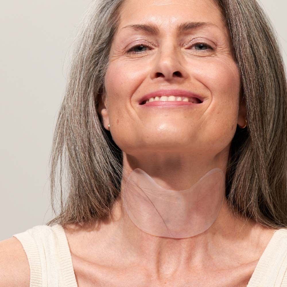 Vrouw met nekpad. Transparant pad op de hals. Vrouw lacht.