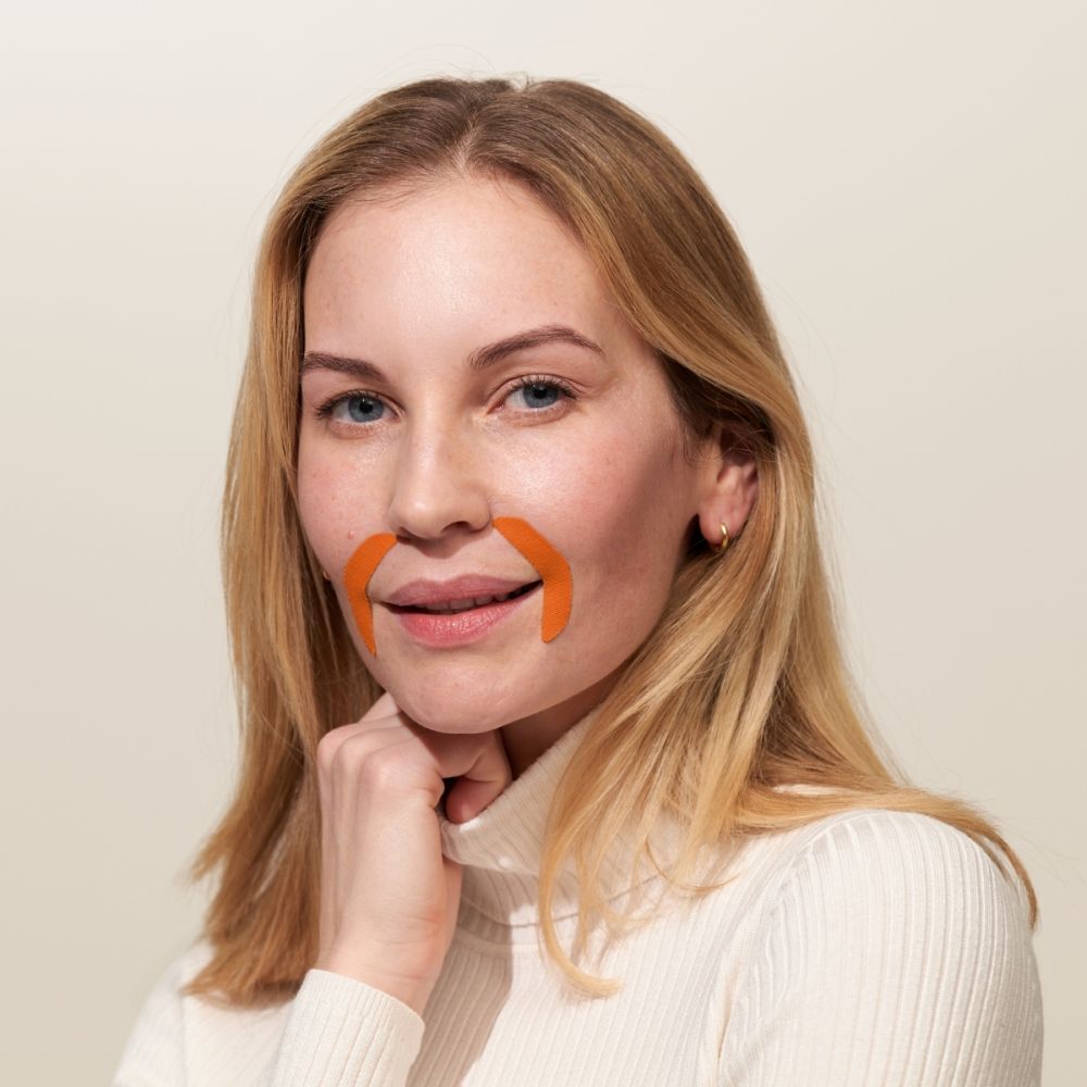 Vrouw met twee oranje APRICOT mond patches op de mondhoeken.
